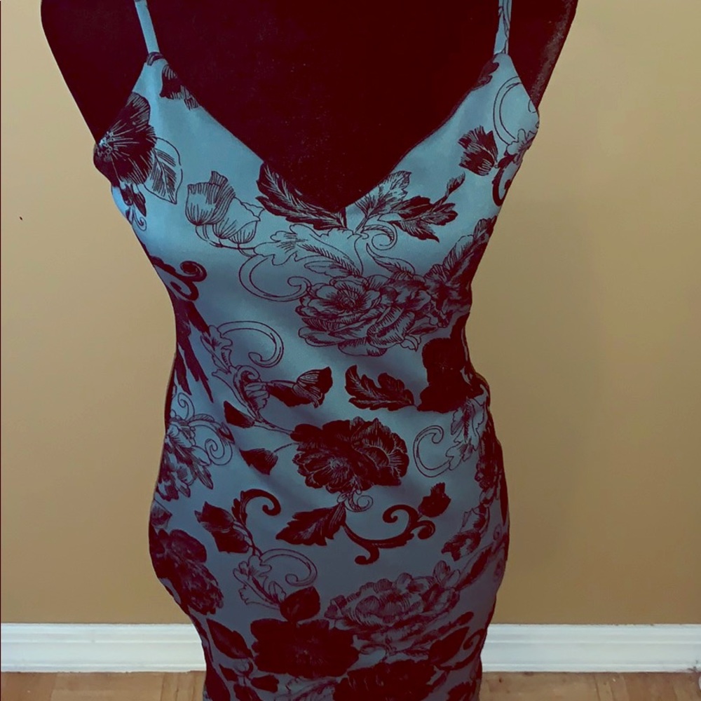 Green form fitting mini dress with black flowers